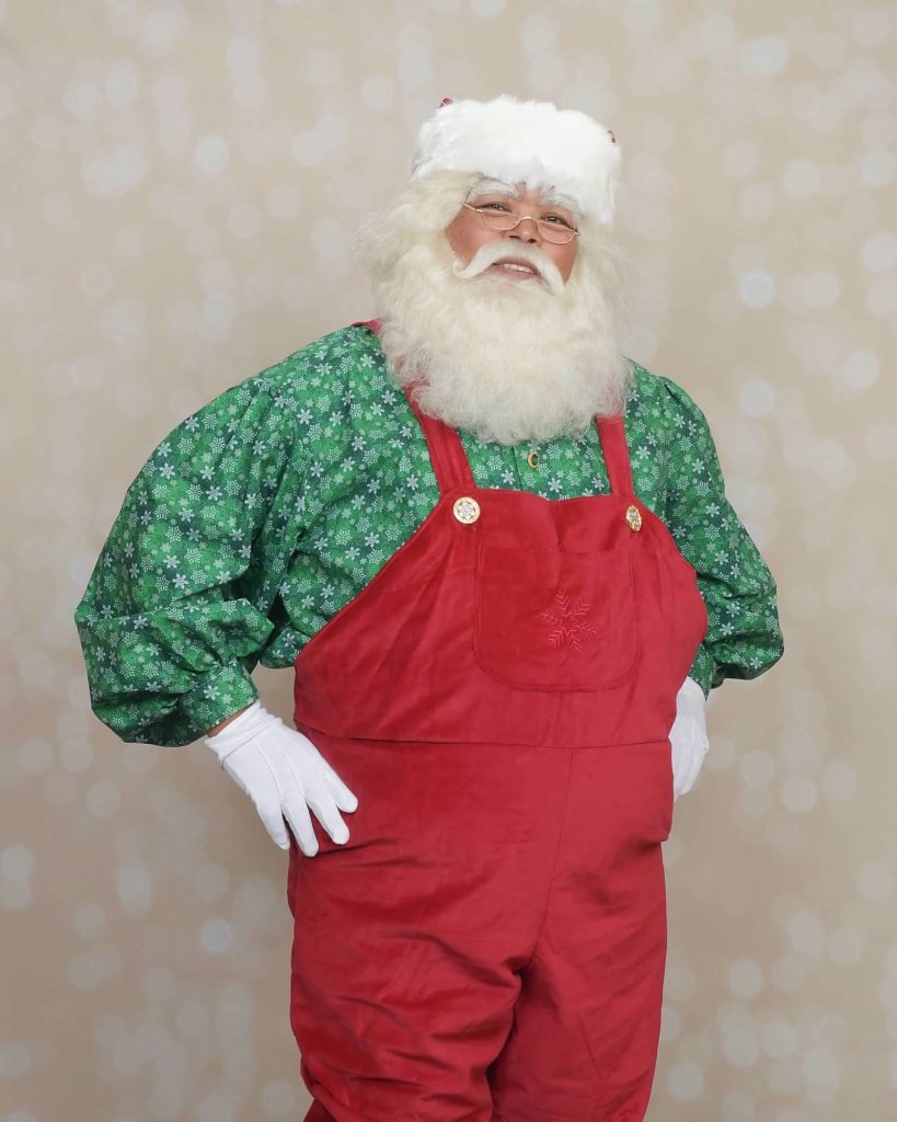 Camano Santa Joe Brigham in red overalls and green snowflake shirt
